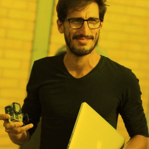 Alvaro holding a camera and a laptop
